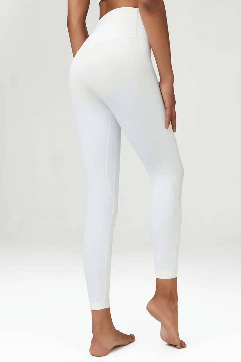 Woman wearing white high-waist yoga leggings, showcasing flexibility and fit. Perfect for gym, yoga, or casual wear. Durable and stylish.